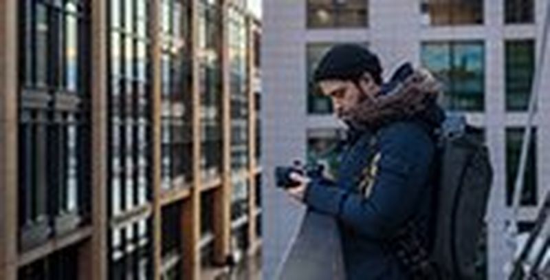 Filmmaker Matthew Vandeputte uses his camera from an elevated position among city buildings. © Pete Jobson
