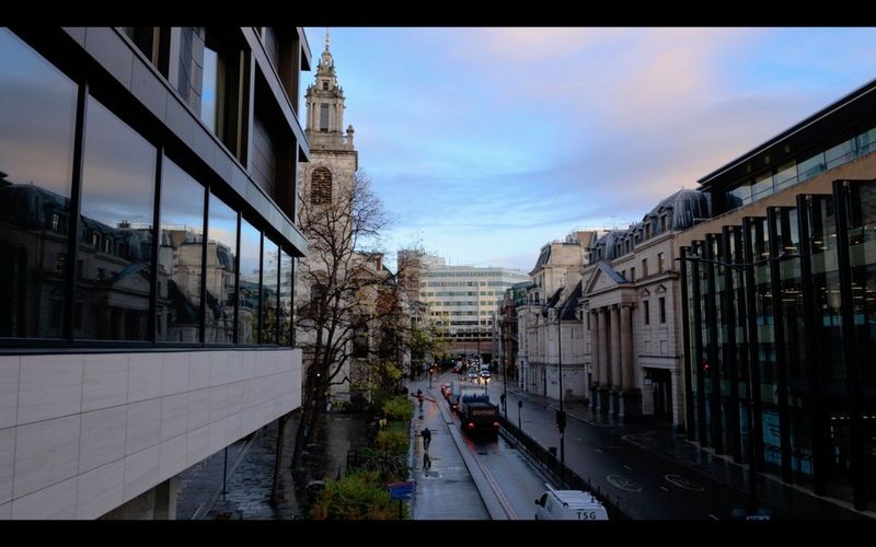 Městská ulice s auty, které se zastavují před semafory.