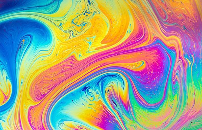 Swirling multicoloured patterns of soap in water. 