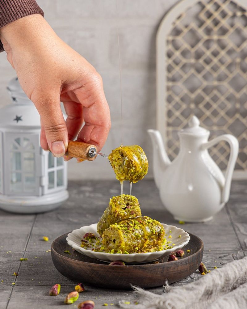 Garnering wordt toegevoegd aan de foto terwijl Yasmin Albatoul een foodcompositie met een Canon-camera vastlegt in de studio.