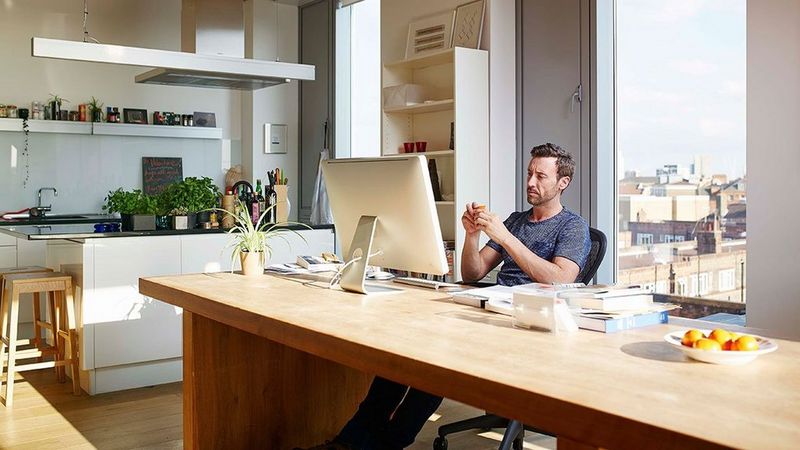 Man aan de keukentafel vanuit huis aan het werk