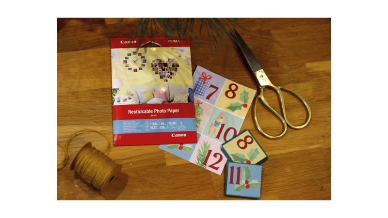 Matériel étalé sur une table en bois, papiers repositionnable paire de ciseaux ficelle.