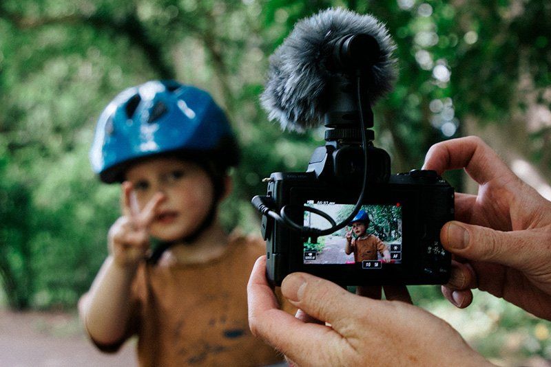 Stef Michalak filming his young son as he makes a peace sign at the camera. 