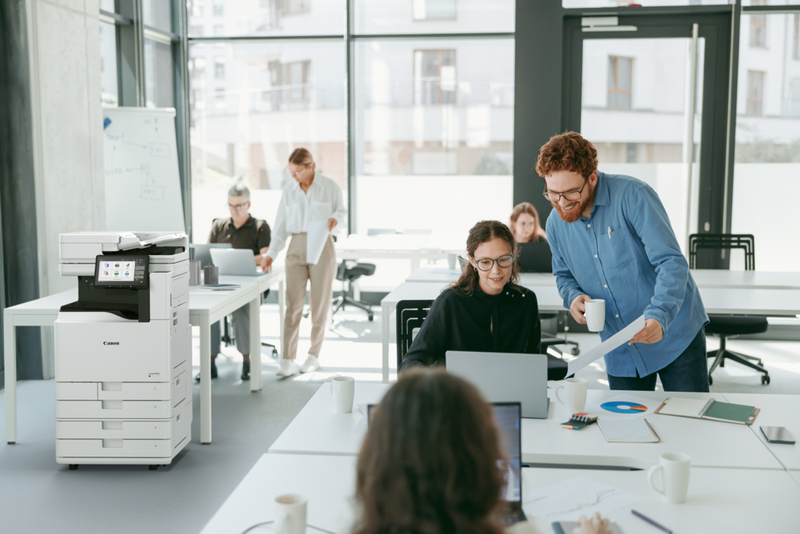Personas trabajando juntas alrededor de un portátil en una oficina