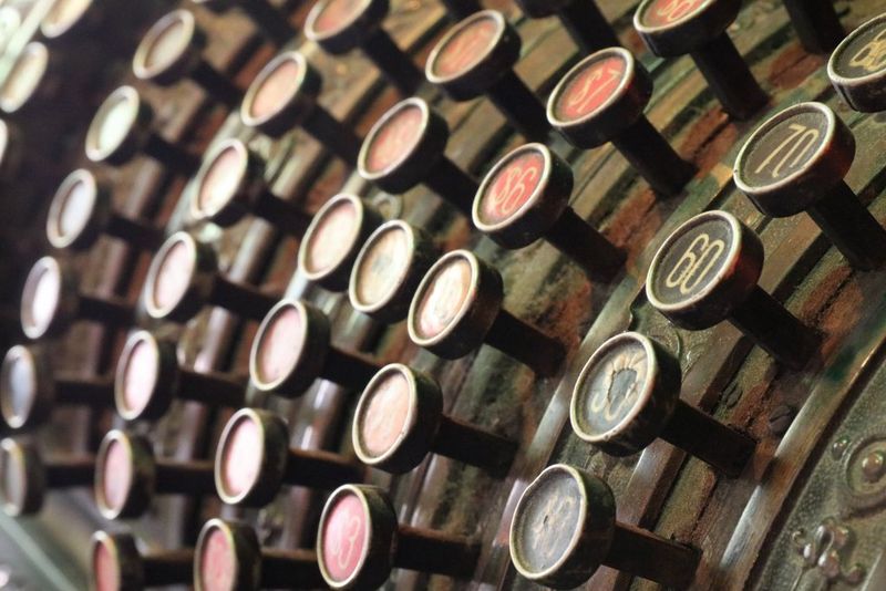 A view of the keys of an old cash register with more of the image appearing in-focus.