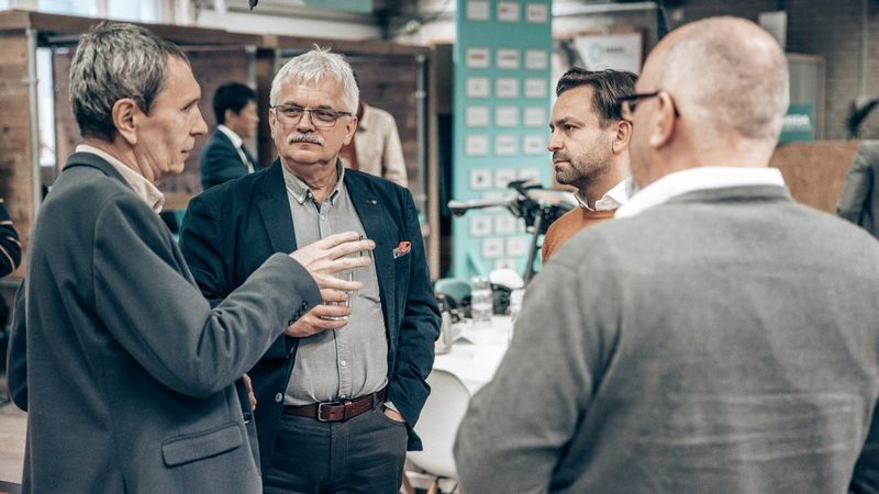 People in in-depth technical conversation at Canon SDK Summit 2023.