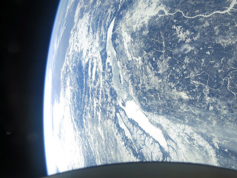 A satellite view of Earth, focusing on a Lake Baikal and surrounding mountainous region.
