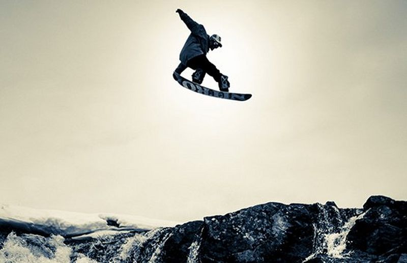 snowboarder performs jump on slope of mountain