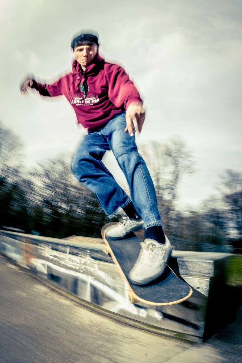 A flash-lit action photo of skateboarder in a park, captured at close range by Lorenz Holder using a Canon EOS R5 Mark II with a Canon fisheye zoom lens and Canon Speedlite EL-5 flash.