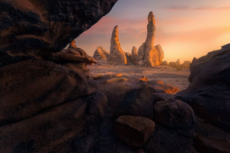 Een foto van een woestijnlandschap met rotsen bij zonsondergang, gezien vanuit een grot. Foto gemaakt door Luka Vunduk met de Canon EOS R5 Mark II.