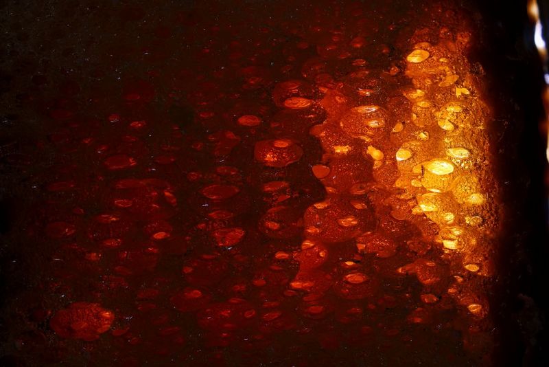 Запечатленный крупным планом в макрорежиме медовый батончик подсвечивается сзади, чтобы воздушные пузырьки выглядели как раскаленные угли. Снято на камеру Canon EOS R10 с объективом Canon RF 100mm F2.8L MACRO IS USM.