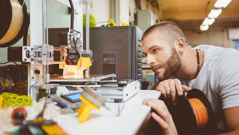 male-looking-at-3D-printer-in-constuction-shop