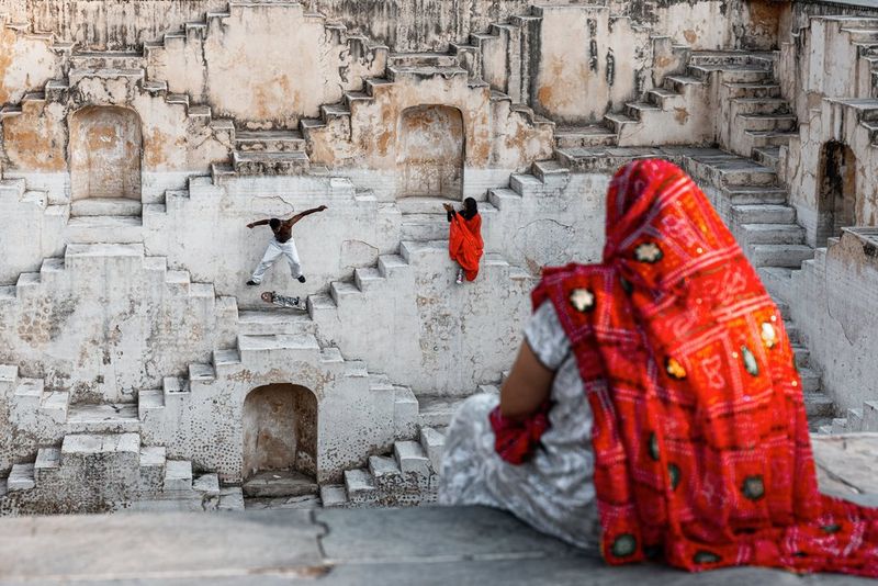 Action photograph of a female skateboarder dressed in red doing a trick at the Panna Meena Kund stepwell in Jaipur, India captured by Martin Bissig on the Canon EOS R5 Mark II. 