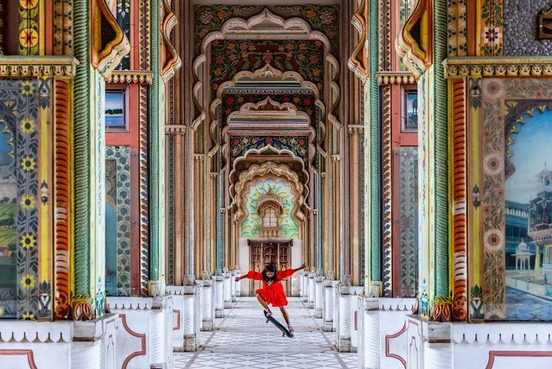 Action photograph of a woman skateboarder does a trick in a corridor of colourful pillars on the streets of Jaipur, India, captured by Martin Bissig on the EOS R5 Mark II.   