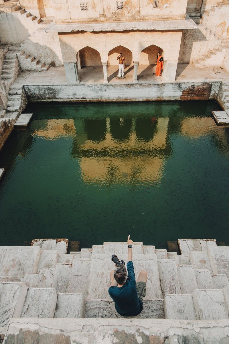 Behind the scenes image of photographer Martin Bissig directing two skateboarders at the Panna Meena Kund stepwell in Jaipur, India.