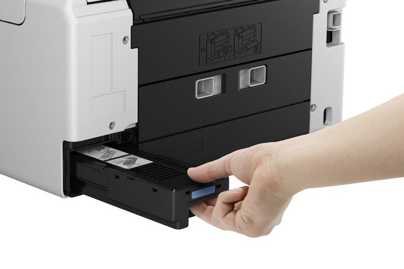 יד של משתמש מסירה את מחסנית התחזוקה שמשתמשים יכולים להחליף בפינה האחורית של מדפסת הזרקת דיו Canon MAXIFY.