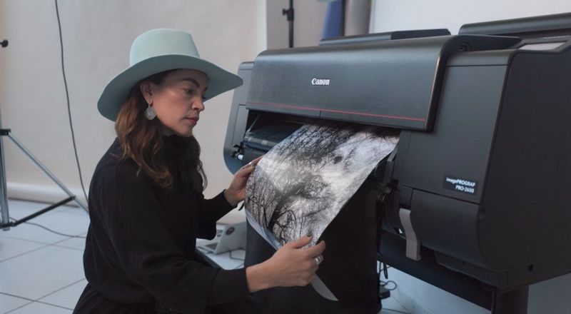 Kuvassa valokuvaaja ja Canon-lähettiläs Meeri Koutaniemi sekä Canon imagePROGRAF PRO-2600-suurkuvatulostin.
