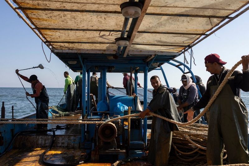 A group of people working on a boat at sea. Shot on Canon.