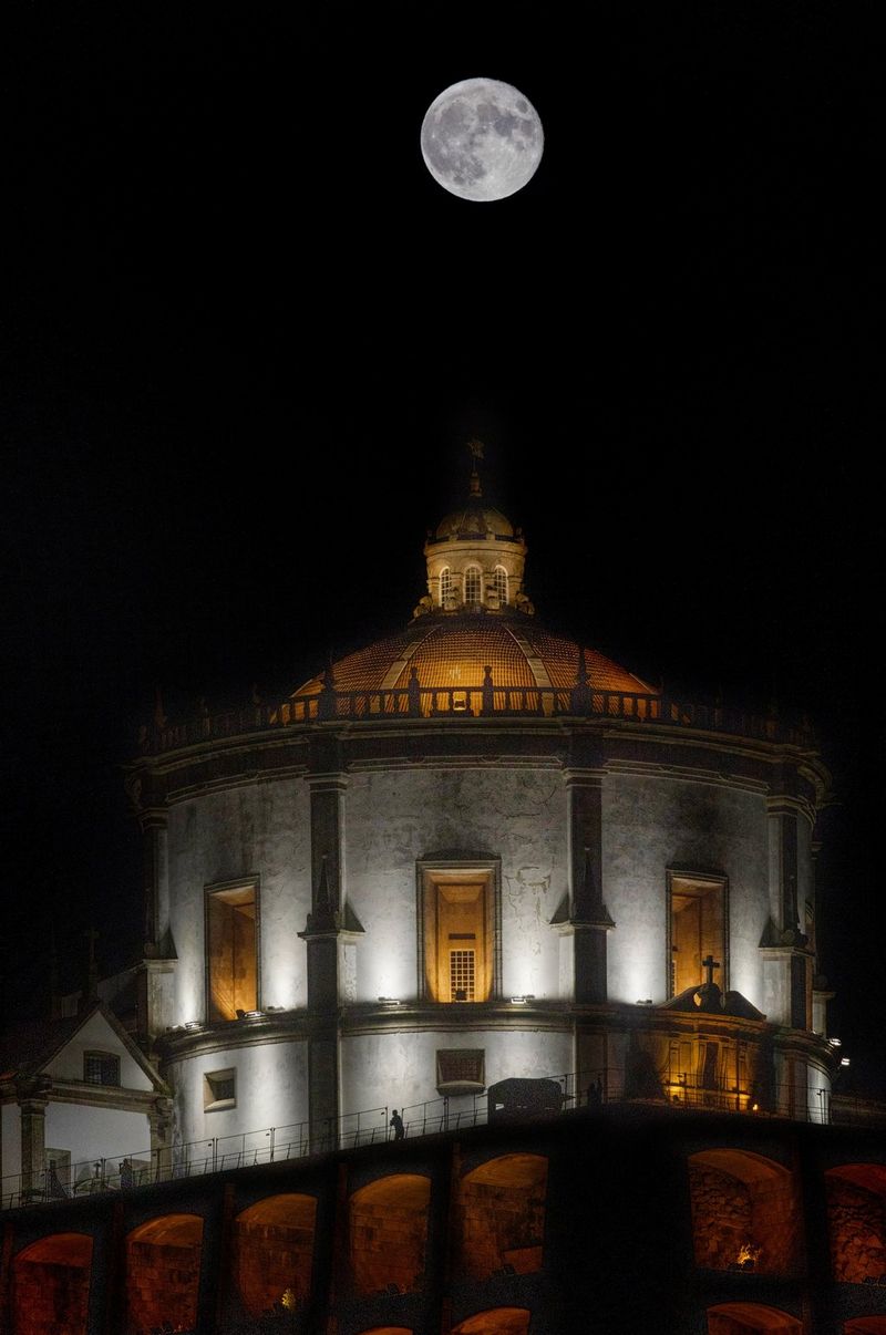 A full moon visible above a Portuguese monastery, taken on a Canon EOS R8.