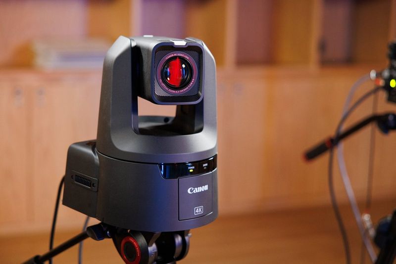 Een Canon PTZ camera op een statief voor het opnemen van videopodcasts in een studio.