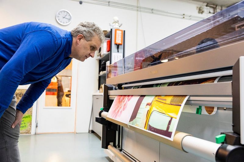 Multicopy employee using Canon UVgel technology on Canon Colorado printer