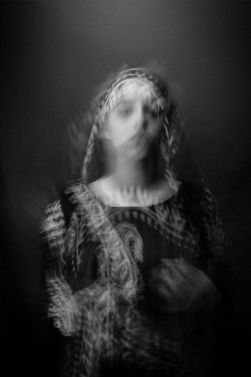A blurred portrait of Niga Salam in traditional Kurdish dress.