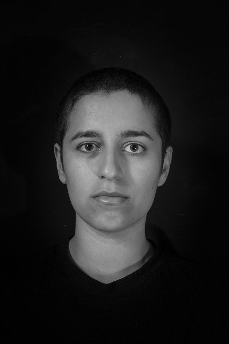 A black and white portrait of Niga Salam with her head shaved.