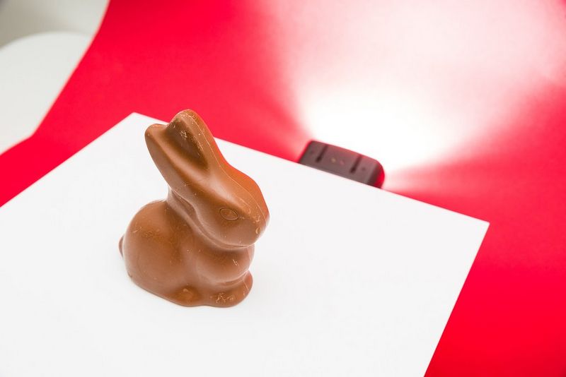 Čokoládový zajačik na bielom akrylovom paneli.