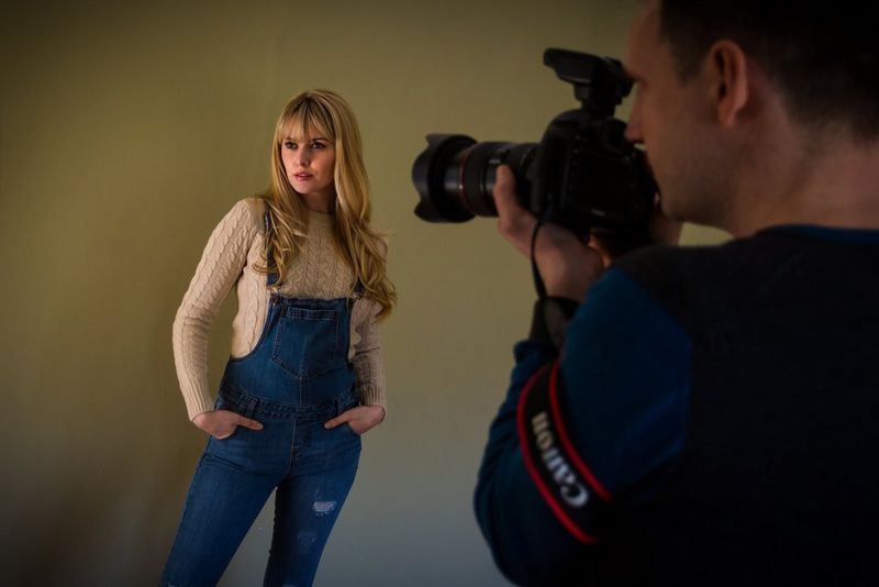 A photographer taking a portrait of a woman with Canon camera, lens, and flash. © Marcus Hawkins