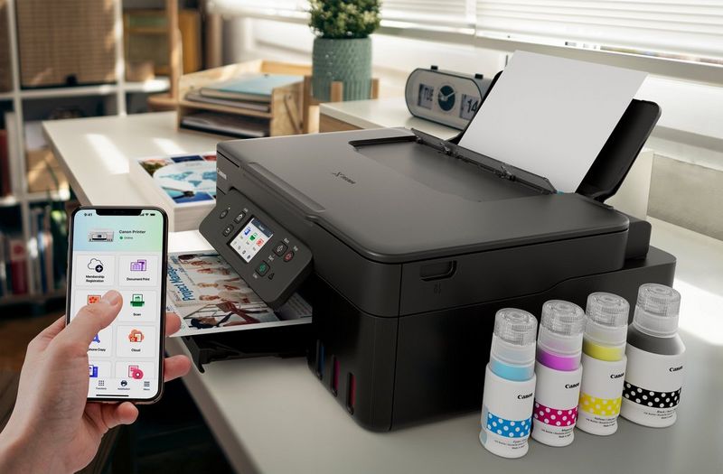 Una stampante Canon PIXMA è posizionata su un tavolo e collegata a uno smartphone tramite l'app Canon PRINT per la stampa wireless.