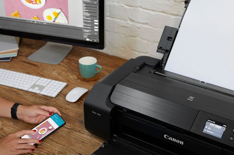 Eine Frau verwendet ihr Smartphone, um mit einem Canon PIXMA PRO-200 Drucker zu drucken.