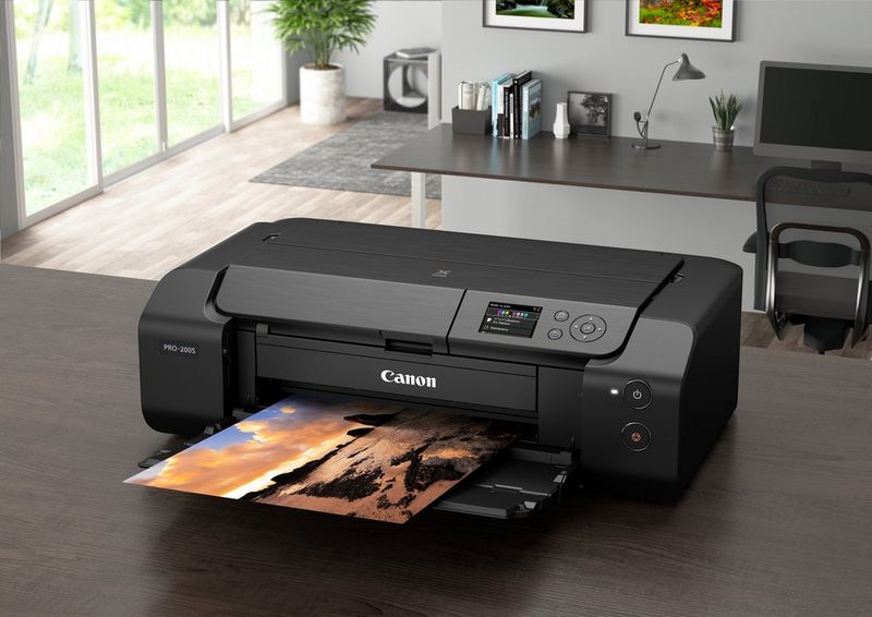Een Canon imagePROGRAF PRO-200S-printer in een modern kantoor met een kleurrijke print van een woestijnlandschap zonder witranden.