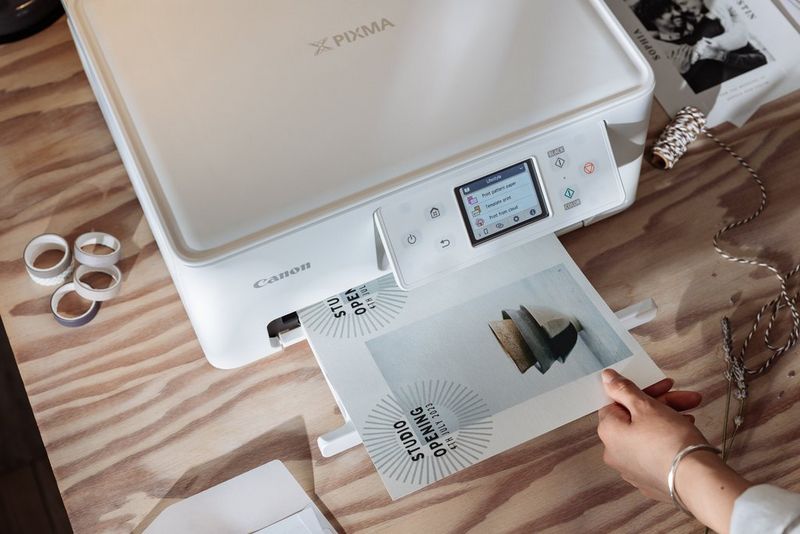 Een zakelijke flyer glijdt uit een Canon PIXMA-printer.