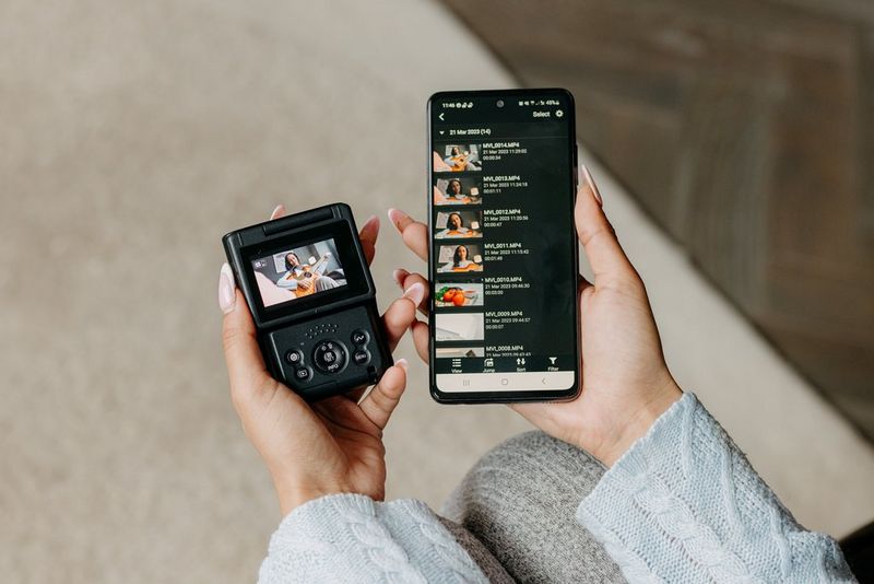 Uživatel drží v jedné ruce kameru PowerShot V10 a v druhé chytrý telefon s aplikací Canon Camera Connect, umožňující přenos souborů z kamery.