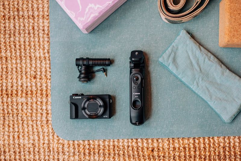 Fotoaparát Canon PowerShot G7 X Mark III na tyrkysové podložce s externím mikrofonem a dálkovým ovládáním.