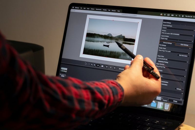 Photographer Julie Stamenic points to her laptop screen, which is displaying one of her landscape photos in Canon Professional Print & Layout.