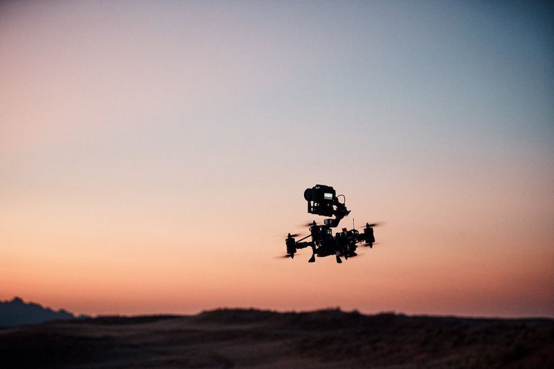 Een Canon EOS R5 C die op een FPV-drone is bevestigd, maakt een vlucht bij zonsondergang.