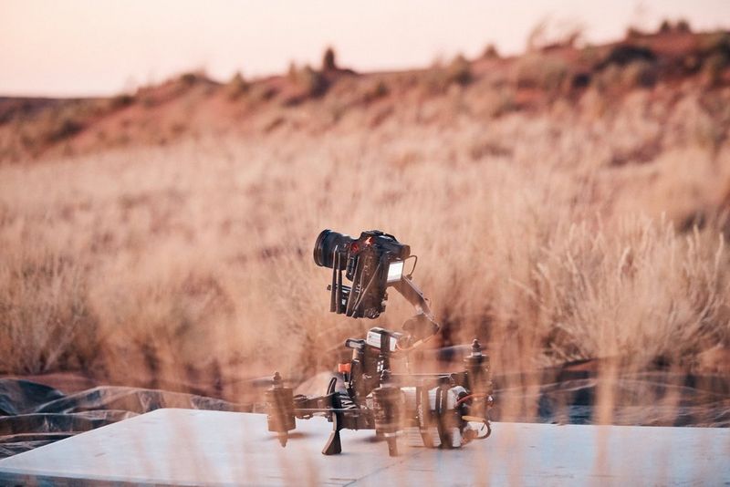 Een Canon EOS R5 C die op een FPV-drone is bevestigd, staat in een veld.