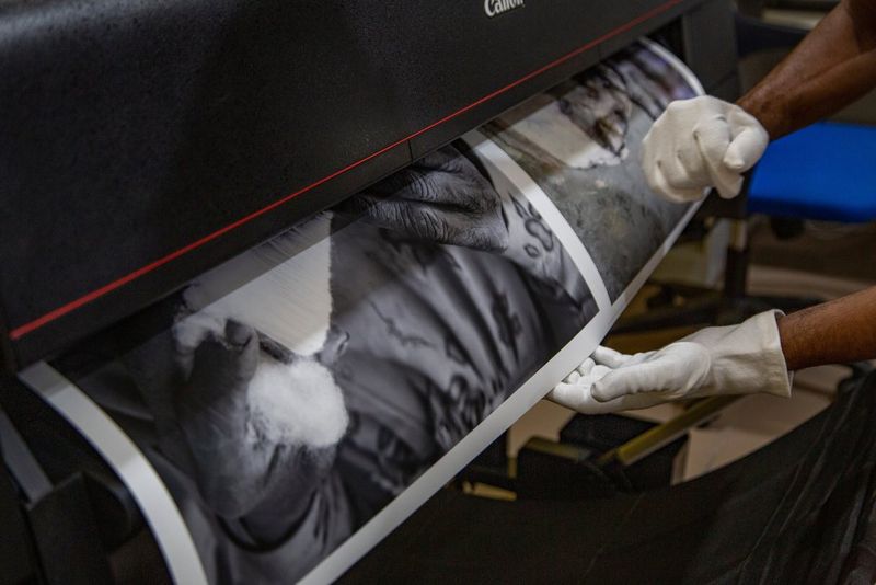Le fotografie in bianco e nero di Eric Lesigne escono da una stampante Canon all'Africa Foto Fair.