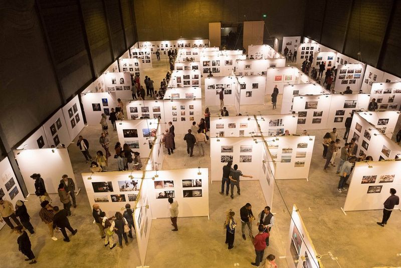 A top down view of a large exhibition hall, with people looking at images displayed on boards at the Addis Foto Fest.