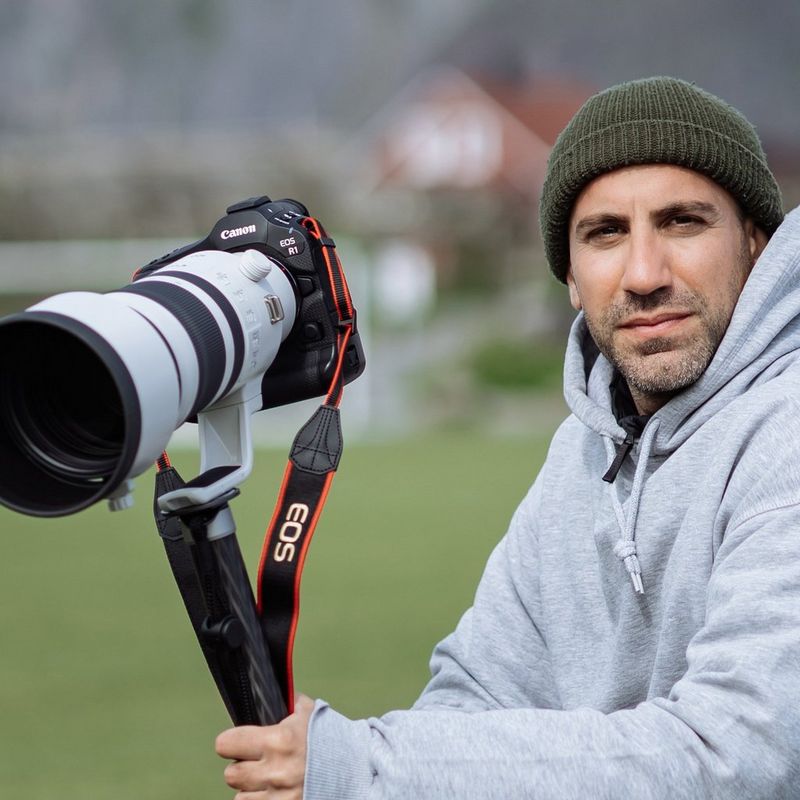 A portrait of Canon Ambassador Alexandros Grymanis with a Canon EOS R1 camera, taken by Andy Ford.