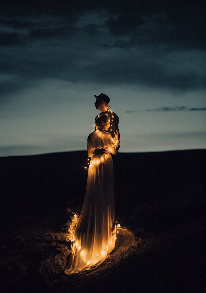 Newlyweds draped in fairy lights embrace under a dark sky. Taken on a Canon EOS 5D Mark IV by Canon Ambassador Askar Bumaga.