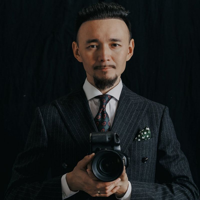 A portrait of Canon Ambassador Askar Bumaga holding a Canon camera.