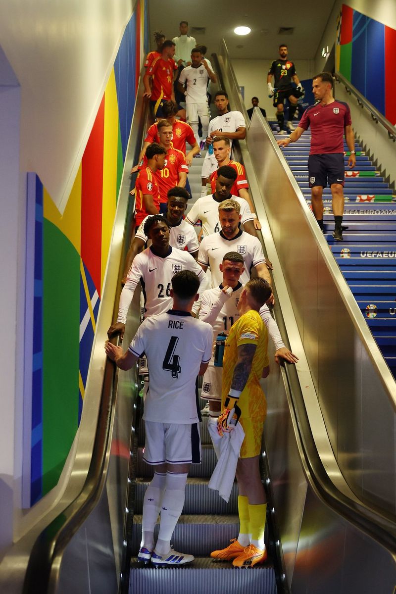 Players from the English and Spanish national football teams standing on an escalator.