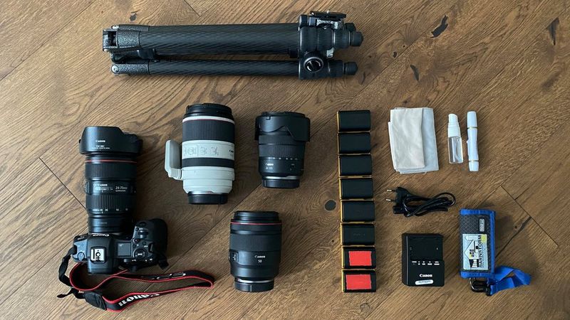 A top-down shot of Evgenia Arbugaeva's kitbag consisting of a Canon EOS R5 and an array of Canon lenses and accessories. 