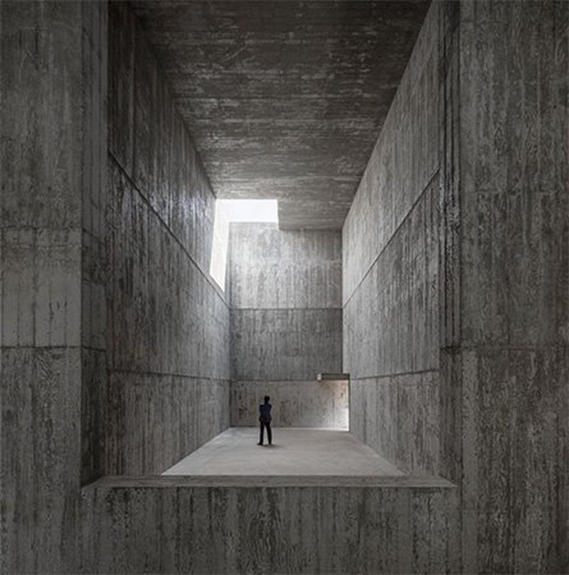 A man stands in the vast concrete gallery at the Saya Park project in South Korea.