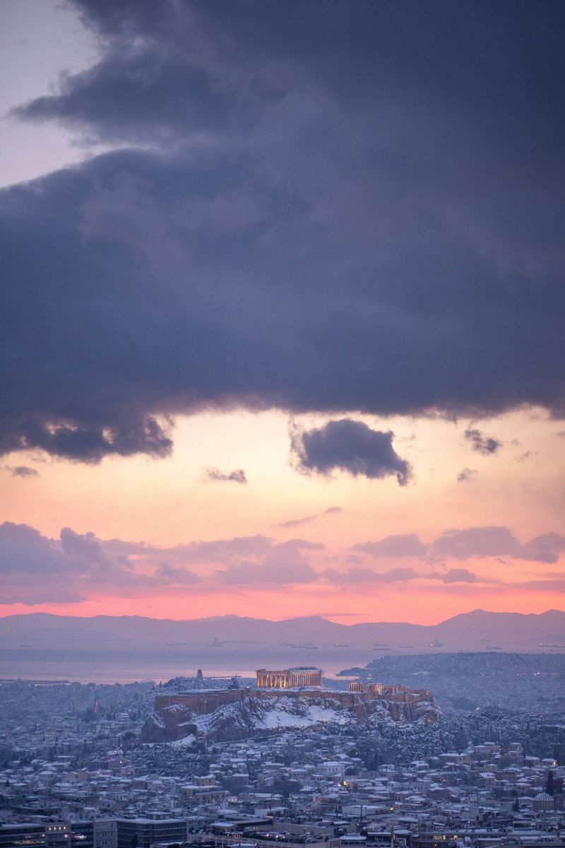 A photo of snowy Athens under a blue and orange cloudy sky, taken by Canon Ambassador George Maschalidis.