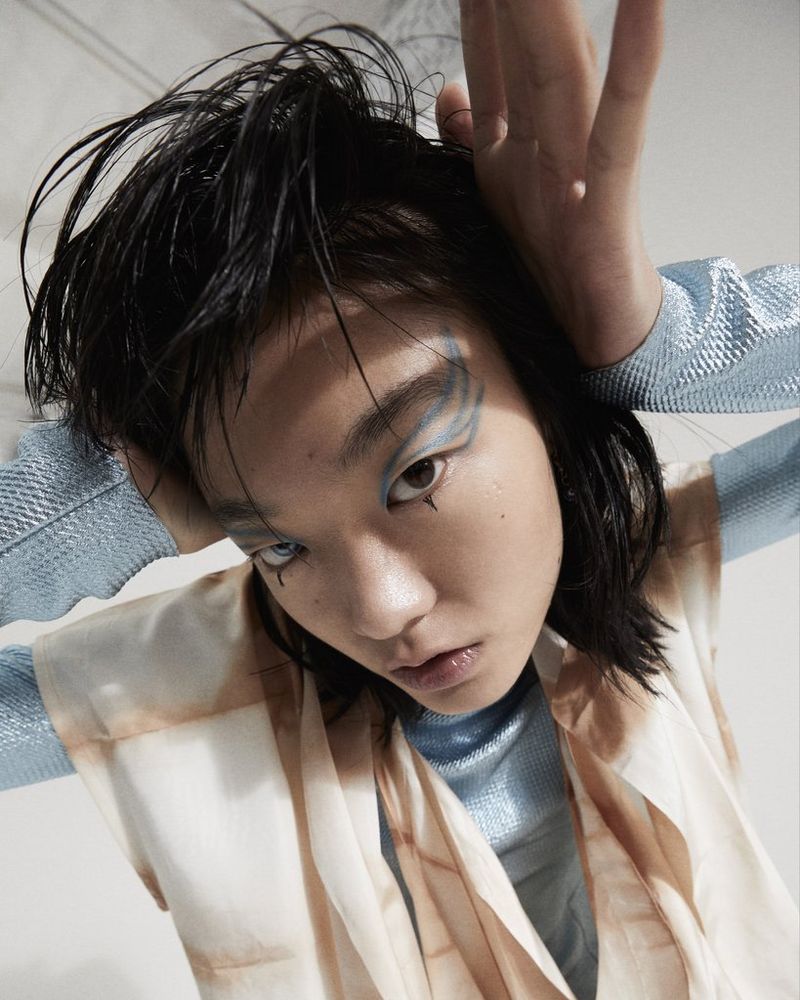 A close-up portrait of a model wearing intricate eye make-up and with her hand pushed against the back of her head, taken by Canon Ambassador Heidi Rondak.