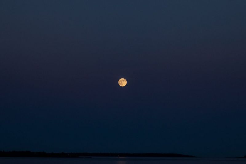 The full moon is visible in the clear sky, in a photo taken by Iiris Sjöblad. 