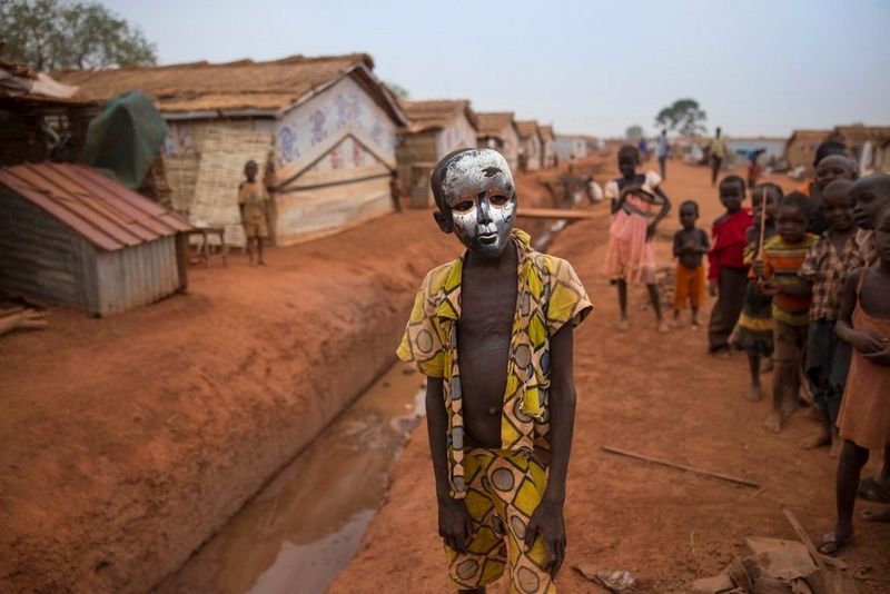 A young boy posing with a mask in an IDP camp in South Sudan.